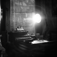 A typewriter sits on a cluttered desk by a window, illuminated by soft light, reflecting the author's journey of working on many projects that almost succeeded but ultimately failed to emerge.